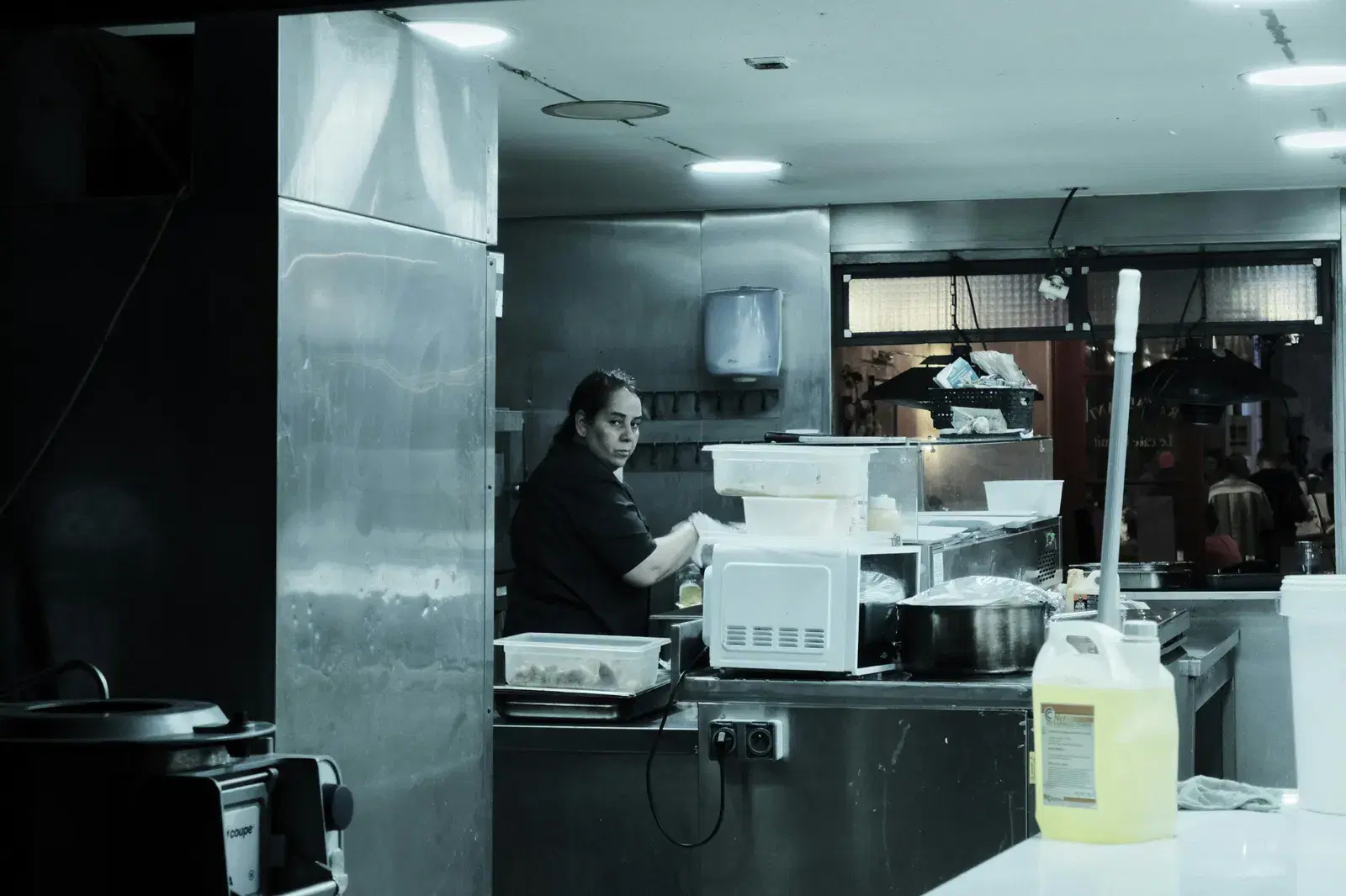 A chef working in a modern kitchen preparing meals for restaurant patrons.